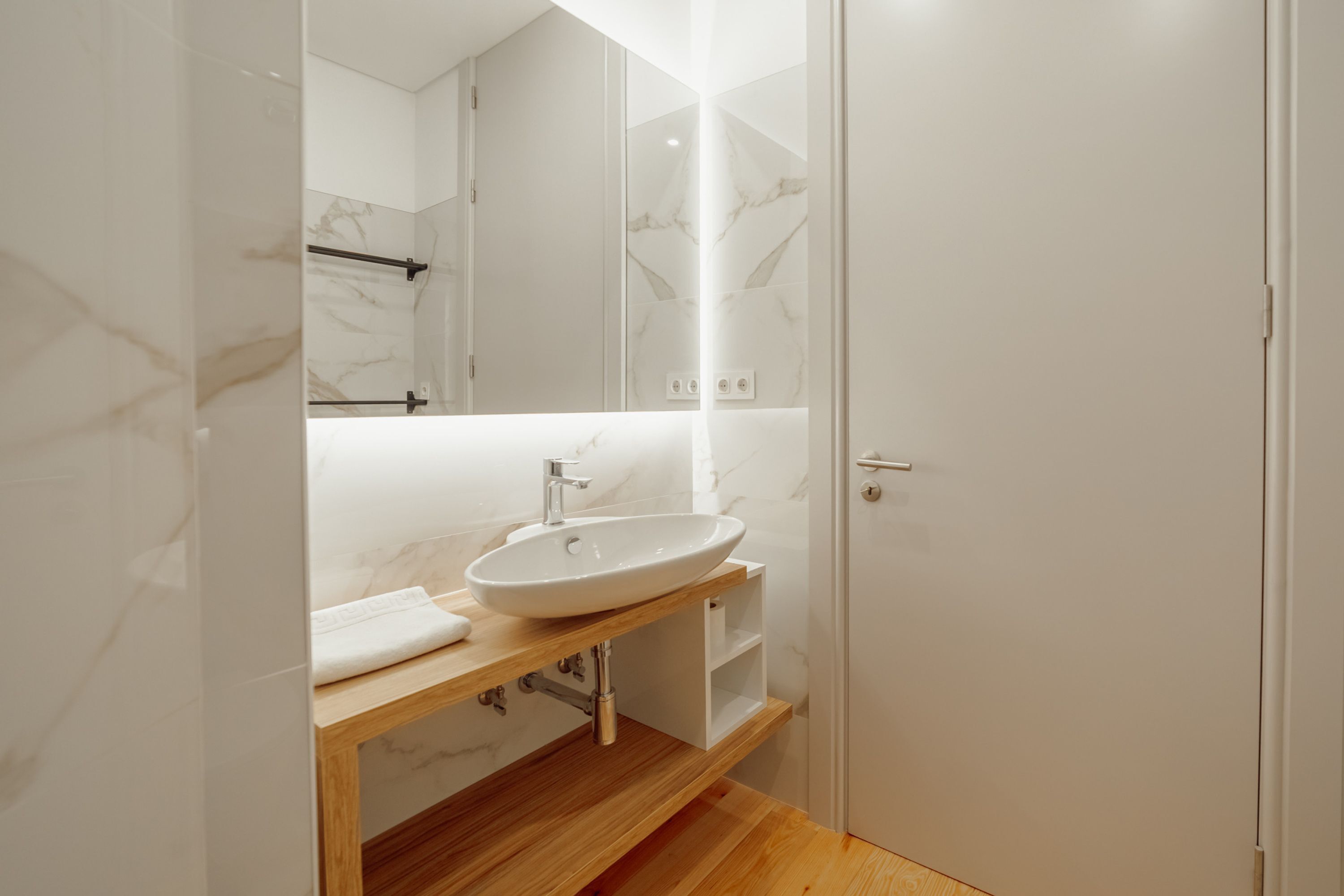 Une salle de bain moderne avec un meuble-lavabo en marbre, un évier et un miroir.