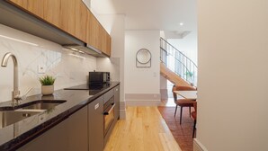 A modern kitchen with a wooden upper cabinet, a stainless steel sink, and a built-in oven. - Heart OF Porto Apartment F Duplex by Vacationy (Porto)
