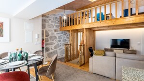 A modern interior with a dining area, a living room, and a loft space. - City Center Comfort Apartment B by Vacationy (Porto)