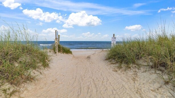 A sandy beach path leading to the ocean, with signs indicating beach access. - Shell Shocked - Short, Breezy Walk to the Beach (Carolina Beach)