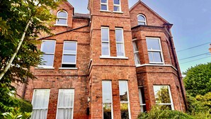 A large, historic brick building with multiple windows and a prominent tower. - Spacious family-friendly & pet-friendly Victorian home in bustling east Belfast (Belfast)