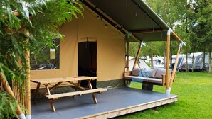A camping site with a tent, picnic table, and seating area. - Camping 2000 - Safaritent Medium (Osecná)