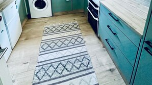 Una cocina pequeña con lavadora, estufa y fregadero.