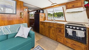 A compact kitchen with wooden cabinets, a stove, and a sink.