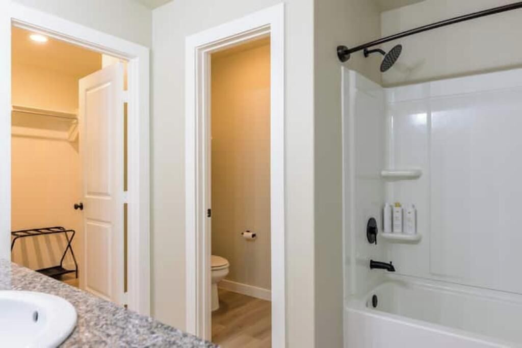 Een badkamer met douche, toilet en wastafel.