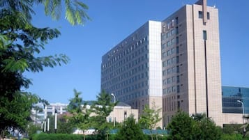 A multi-story building with a modern architectural design, featuring a prominent corner section and a flat facade.