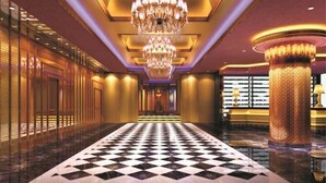 A grand hallway with a black and white checkered floor, a large ornate chandelier, and a tall pillar with a textured surface. - Yangling International Conference & Exhibition Center Hotel (Xianyang)