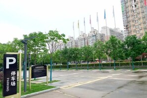 A parking lot with a sign indicating a parking area, surrounded by trees and buildings in the background. - Yangling International Conference & Exhibition Center Hotel (Xianyang)