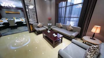 A hotel lobby with a sofa set, a coffee table, and a lamp.