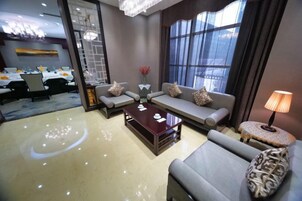A hotel lobby with a sofa set, a coffee table, and a lamp.