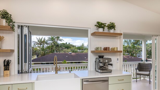 A modern kitchen with a dishwasher, a coffee machine, and a view of the outdoors.