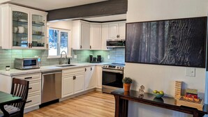 A modern kitchen with white cabinets, a built-in oven, a microwave, and a toaster.