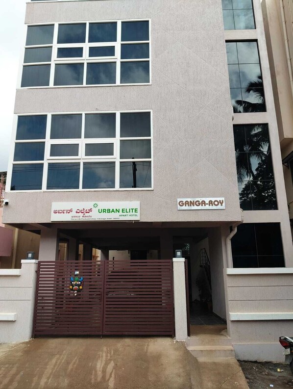 Un edificio de varios pisos con un letrero que dice "URBAN ELITE APART HOTEL" y "GANGA-ROY".