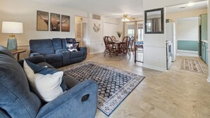 A spacious living area with a dark blue sofa, a patterned rug, and a dining table with chairs. - Family Friendly 4 Beds/Sleeps 6 In Peaceful Westland (Westland)
