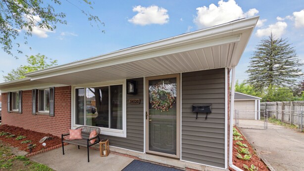 A single-story house with a covered porch, a mailbox, and a door with a wreath. - Family Friendly 4 Beds/Sleeps 6 In Peaceful Westland (Westland)