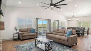 A spacious living room with two sofas, a coffee table, and a ceiling fan.
