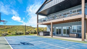 A basketball court with a wooden deck and a balcony overlooking the court.