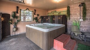 Ein Wellnessbereich mit Whirlpool, einer Holzbank und einem kleinen Tisch mit Stuhl.