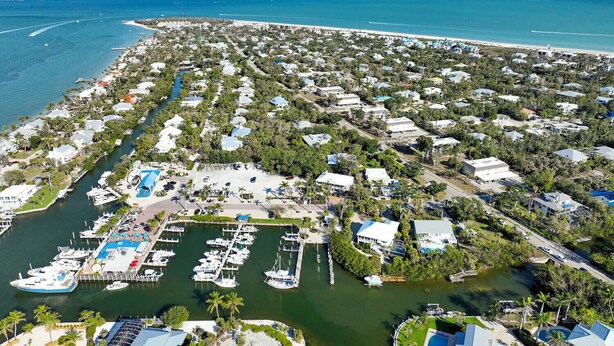 An aerial view of a coastal residential area with houses, a marina, and a beach. - Captain's Haven Sanibel, with Pergola on East End (Sanibel)