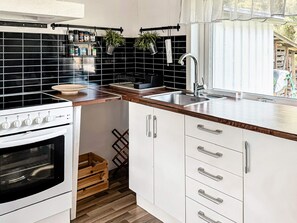 A kitchen with a stove, sink, and cabinets. - 7 Person Holiday Home in Hestra (Hestra)