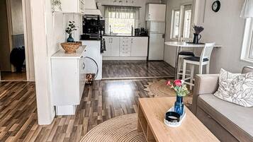 A compact living space with a kitchenette, a dining area, and a seating area with a coffee table.
