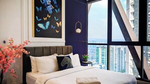 A modern bedroom with a large bed, a view of the city, and a painting of butterflies. - Scarletz Suites KLCC By Numa (Kuala Lumpur)