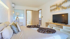 A modern hotel room with a large bed, a flat-screen TV, and a minimalist decor.