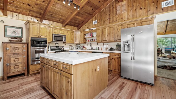 Una cocina amplia con armarios de madera, un refrigerador de acero inoxidable y una isla central.