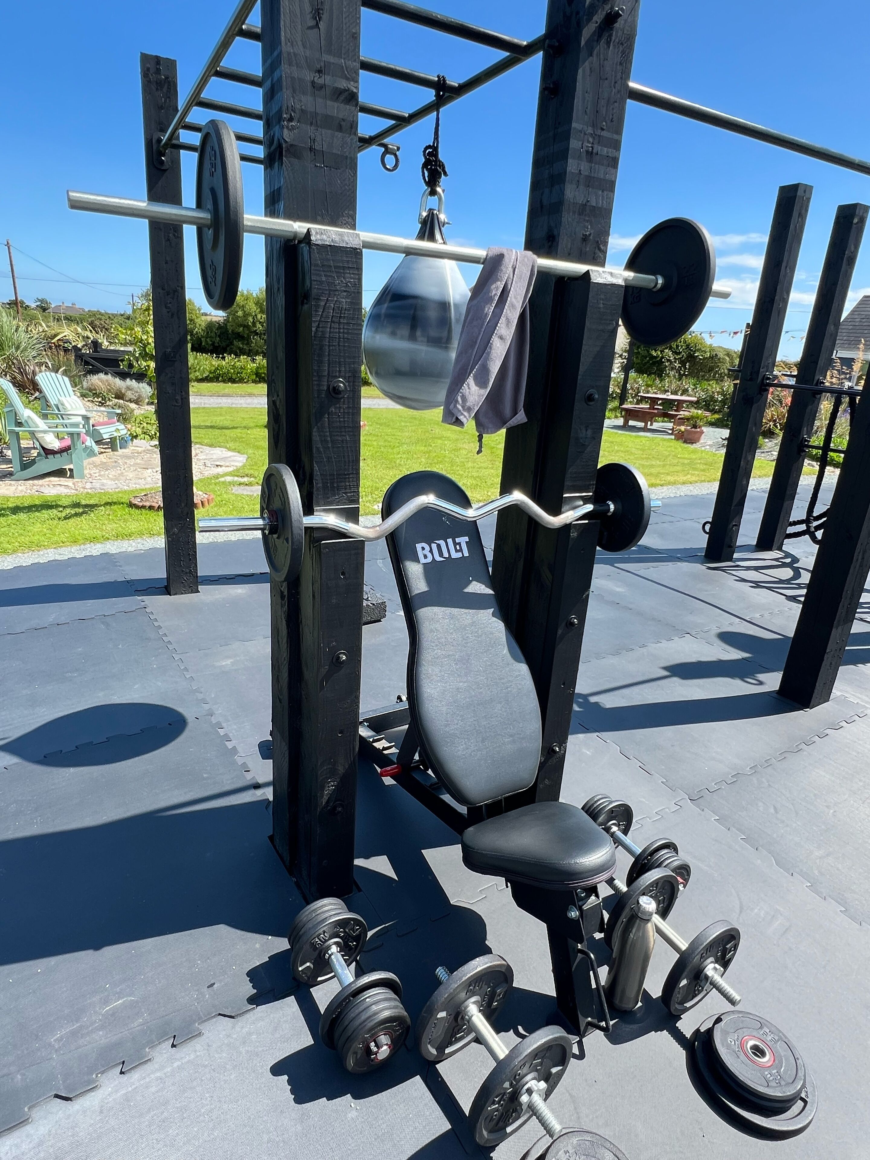 A weightlifting station with a bench, barbell, and various weights.