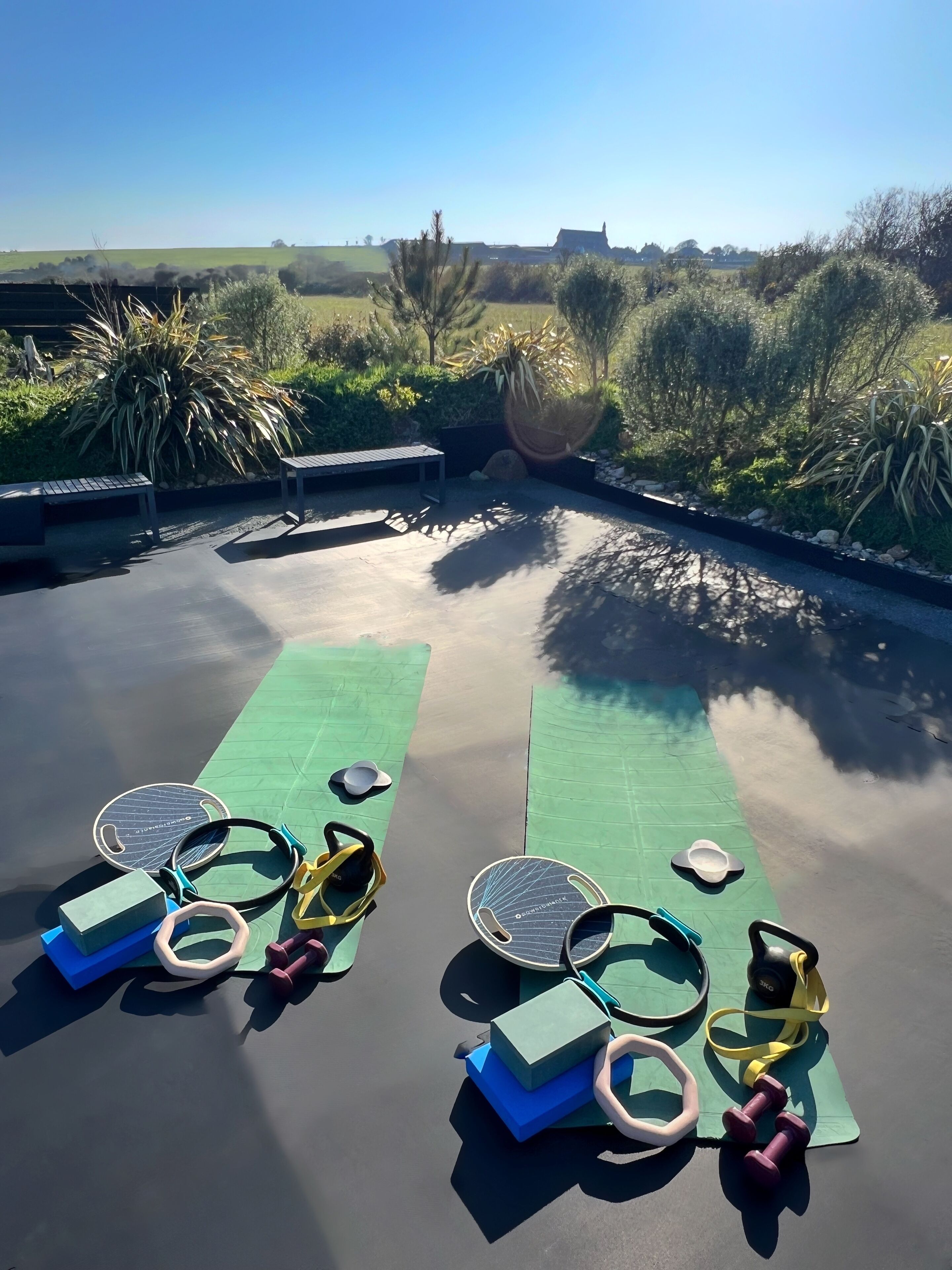 A rooftop with exercise mats, yoga mats, and dumbbells.