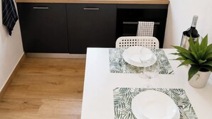 A compact kitchen with a sink, cabinets, and a dining area with a table set for two. - 2 minutes from the sea and all services. 9 minutes by car from the airport (Fiumicino)