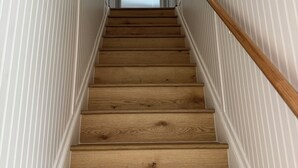 A wooden staircase with white paneling on the walls, leading to a door at the top. - Quaint home with large yard, pet friendly, bike storage right off the trailhead (Lanesboro)