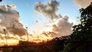 A wooden deck with a metal railing overlooking a landscape with trees and a sunset. -  Pipa Universo (Tibau do Sul)