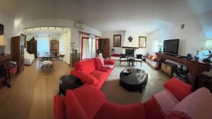 Un salon avec un canapé rouge, un meuble en bois et un téléviseur.