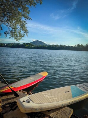 A paddleboard by a calm lake with a mountain in the background. - Va Riverside Retreat (Hue)
