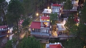 A cluster of modern, multi-story buildings with red roofs, surrounded by dense forest. - BluSalzz Escapade, Lansdowne - Uttarakhand (Lansdowne)