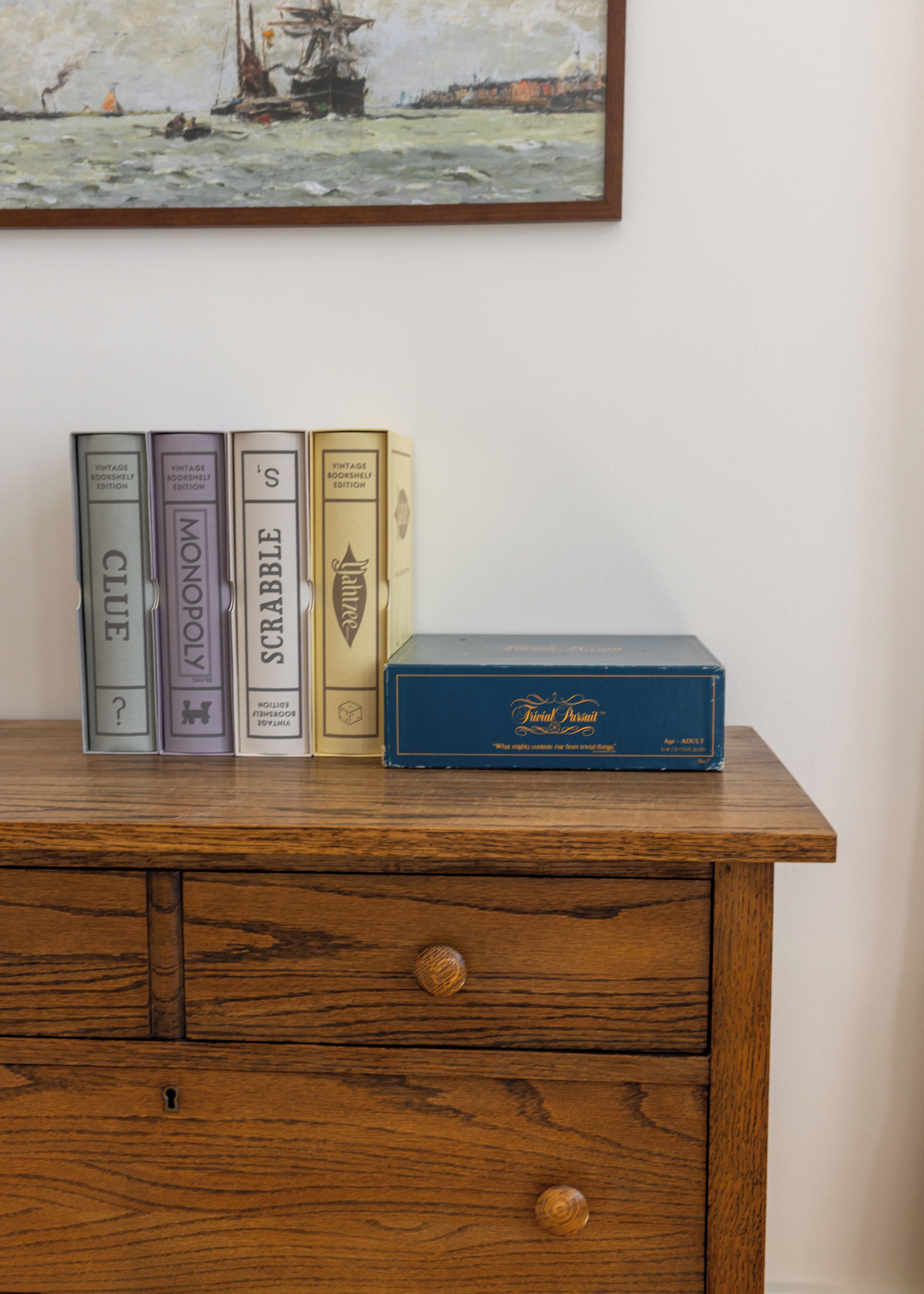 A wooden dresser with vintage books and a box of cigarettes.