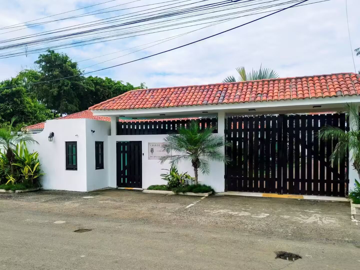 Un bâtiment à deux étages, avec un toit recouvert de tuiles rouges, un portail noir et une enseigne sur laquelle on peut lire « Casa de Boda ».