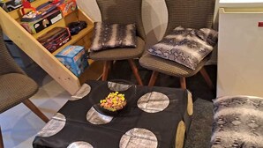 Une petite pièce avec une table, quatre chaises et une bibliothèque.