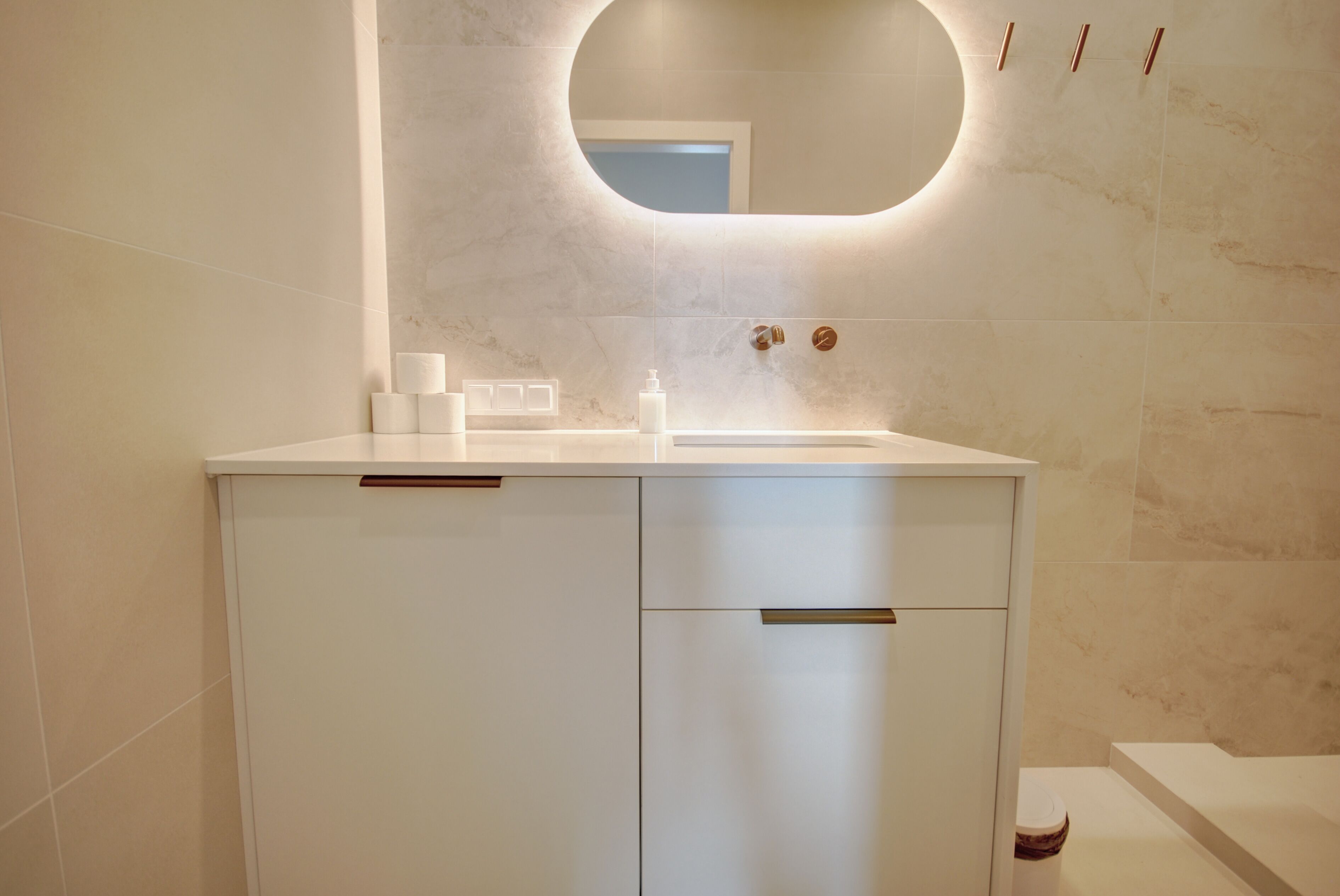 A modern bathroom with a white vanity, a mirror, and a bathtub.
