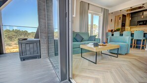 Una sala de estar moderna con un sofá, una mesita de centro y vistas al exterior.