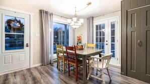 A dining area with a chandelier, a table, and chairs. - Aux Souvenirs doux CITQ 303027 (Lac-Etchemin)