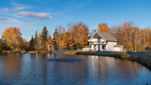 A house by a calm lake with autumn trees in the background. - Aux Souvenirs doux CITQ 303027 (Lac-Etchemin)