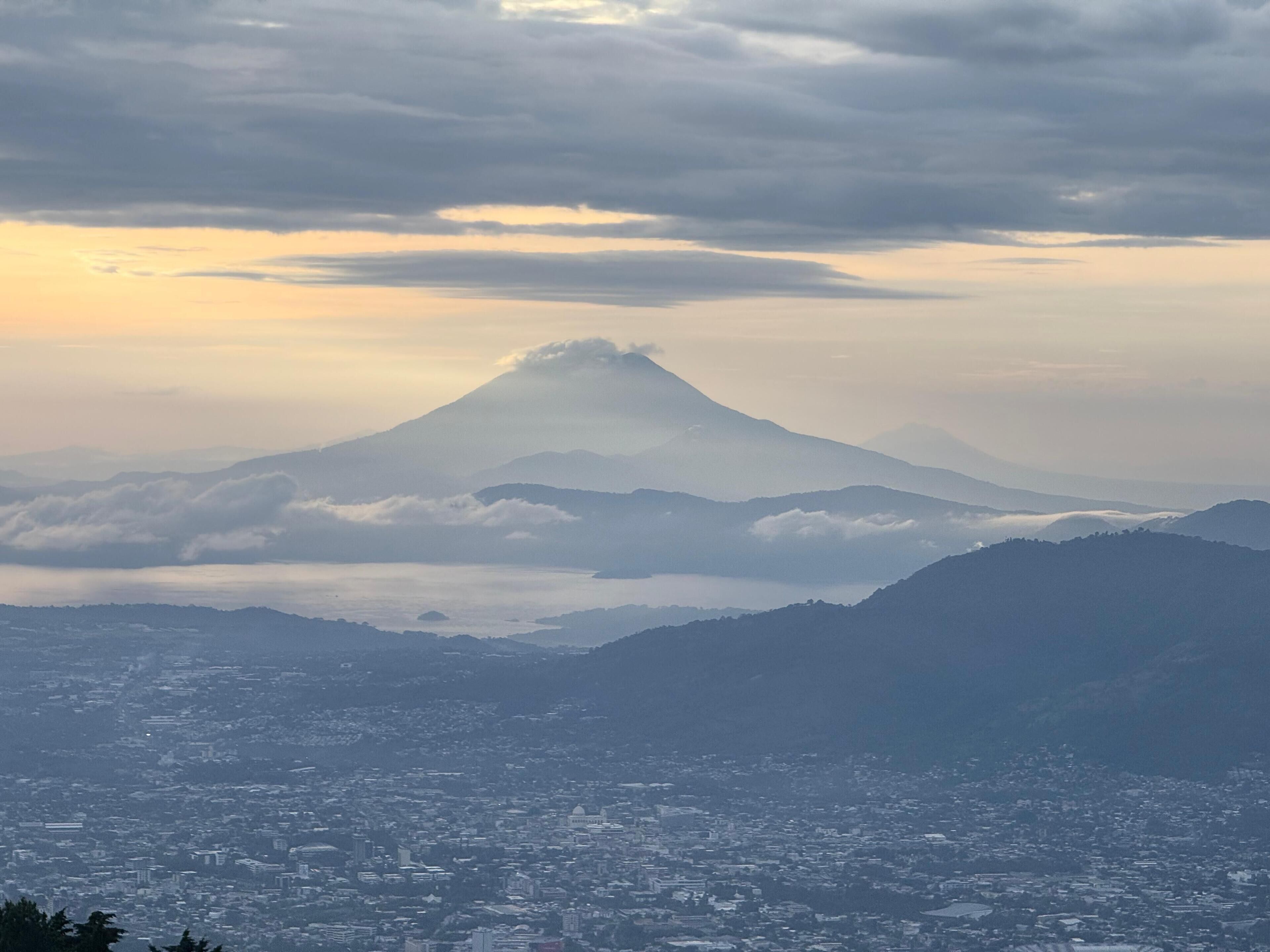 A cityscape with a prominent mountain in the background.