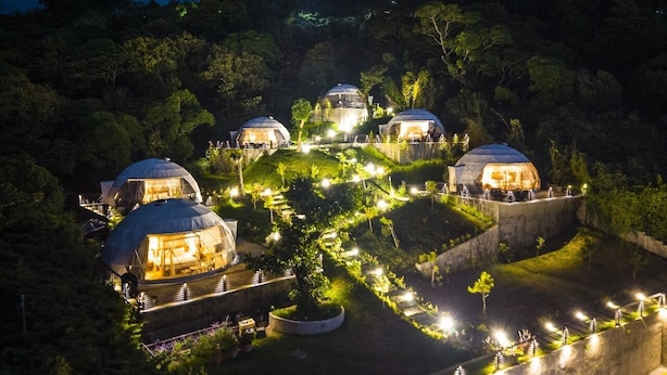 A series of dome-shaped accommodations surrounded by landscaped gardens and pathways, illuminated by artificial lighting. - CARDEDEU DOMOS (Santa Tecla)