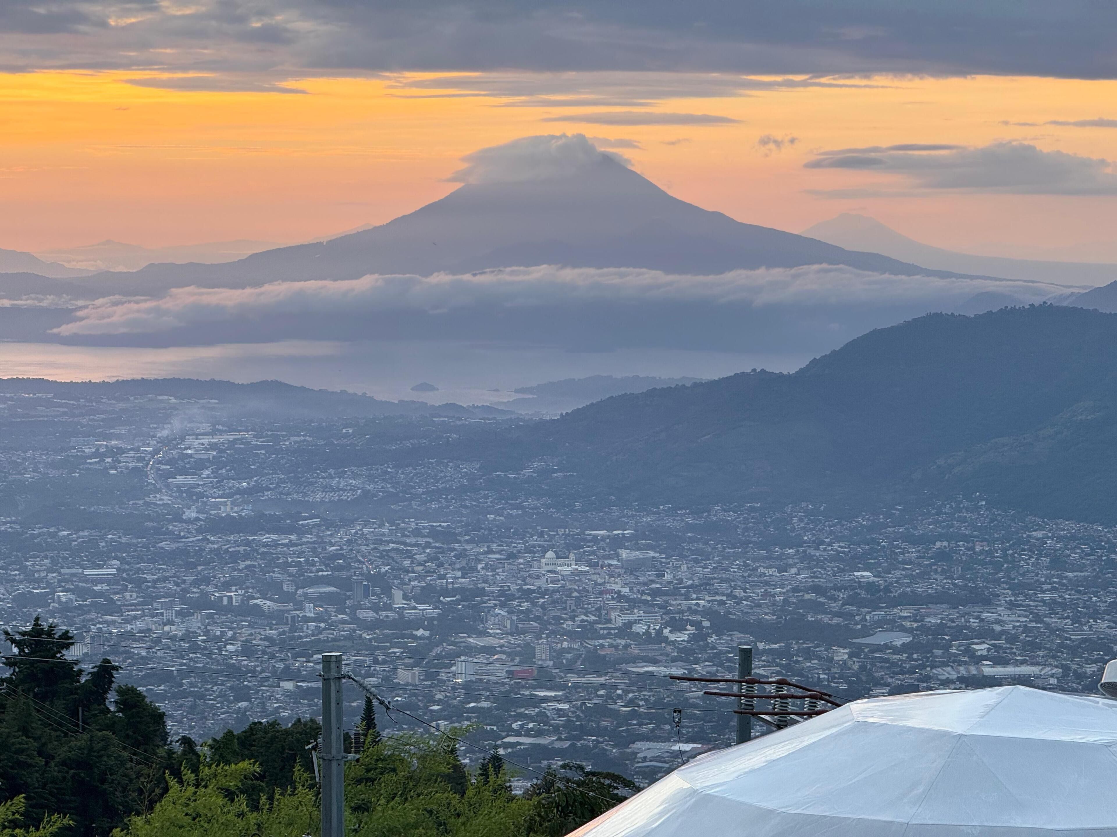 A cityscape with a prominent mountain in the background.