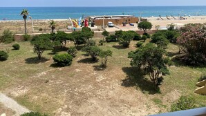 A beachside property with a sandy beach, palm trees, and colorful sculptures. - 2-Room Apartment Sleeps 5 with Parking in Barcarès (Le Barcarès)