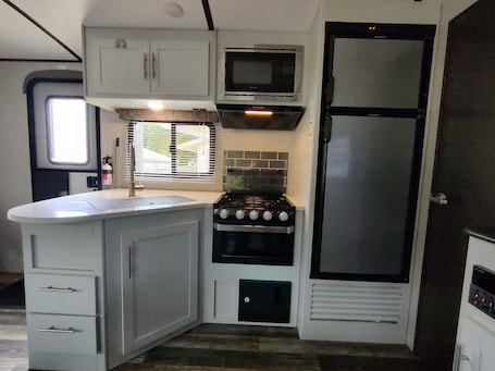 Microwave, oven, stovetop. Cozy RV in Quaint Klamath with AC, WiFi, DISH network, fully hooked up.