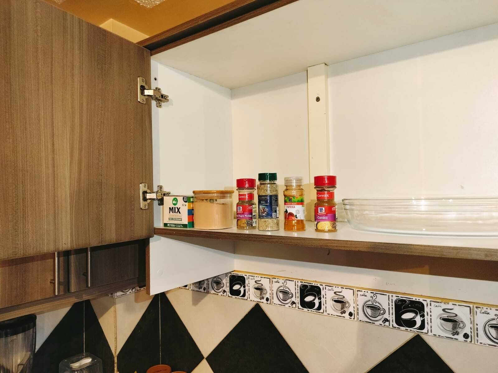Una cucina con un armadietto in legno, una dispensa per spezie e uno schienale a tema caffè.
