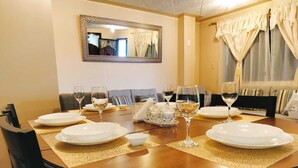 A dining room with a round wooden table set for four, surrounded by chairs. - Incredible apartment with private cinema (pet friendly) (Riobamba)